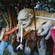 Three Guests brandishing swords at a statue of a troll